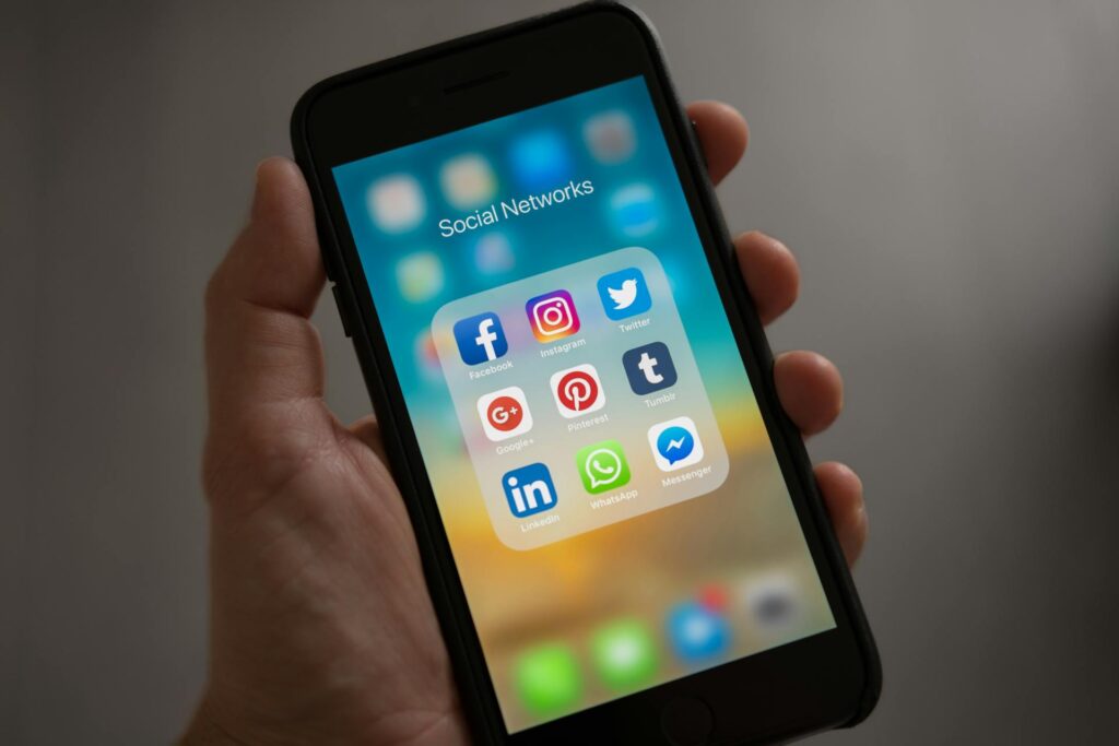 Smartphone screen with various social network icons, illustrating the multi-platform social media advertising, social media management, and lead generation strategies by MetaBaz for GTA businesses.