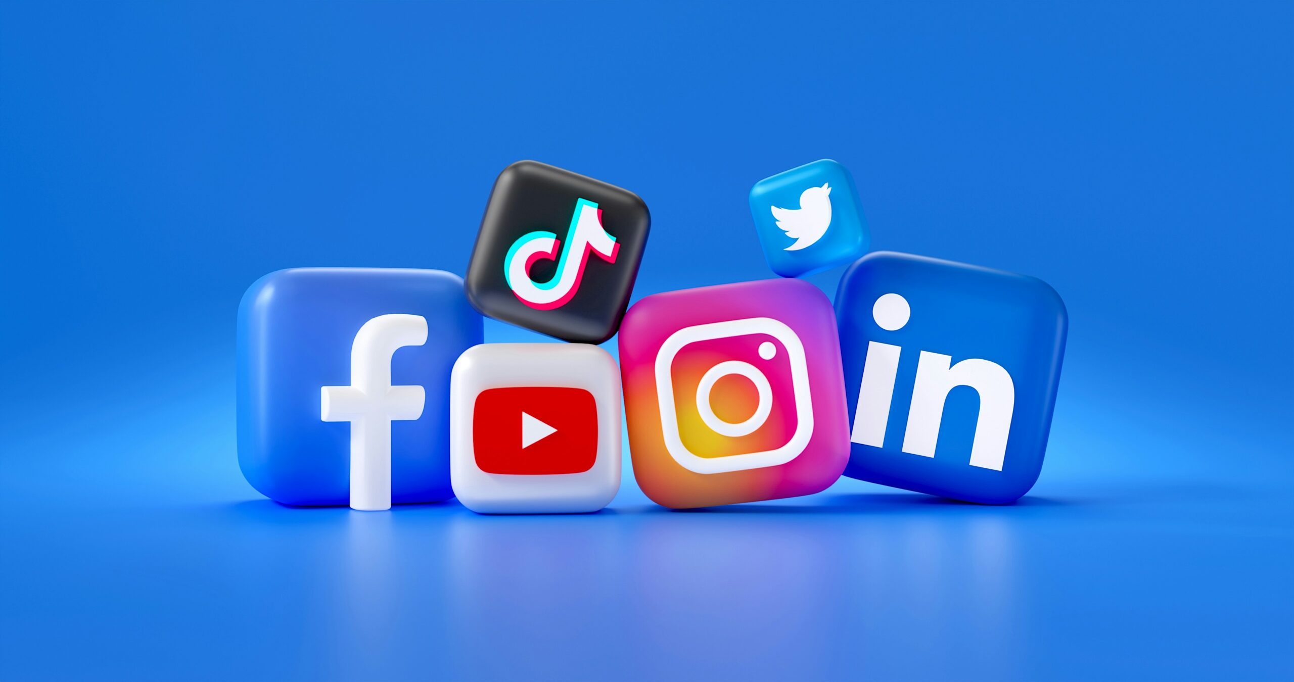 3D render of various social media icons including Facebook, TikTok, Instagram, LinkedIn, and YouTube on a bright blue background, representing professional multi-platform management.